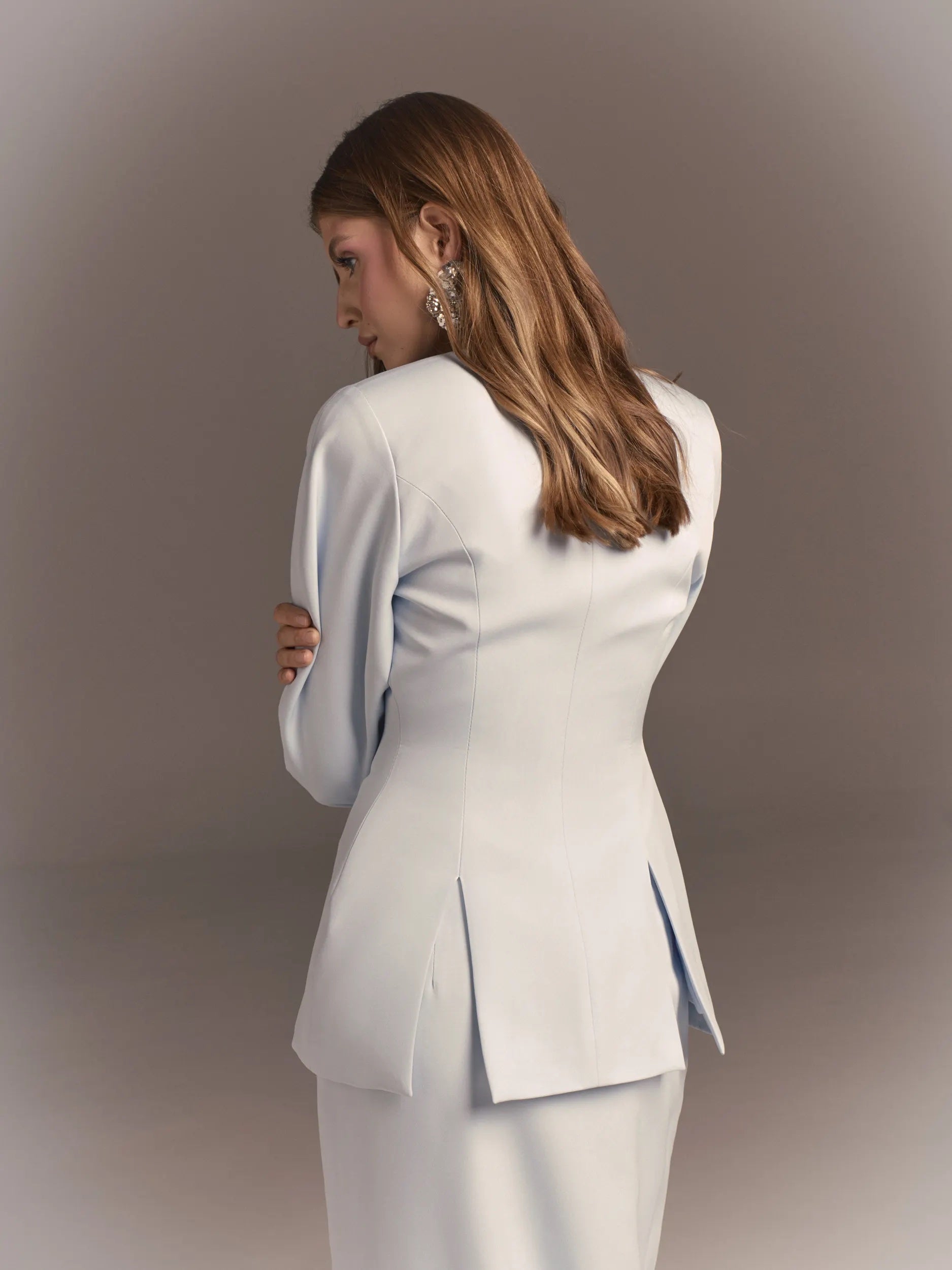 The jacket is fitted with slits at the back and a bow