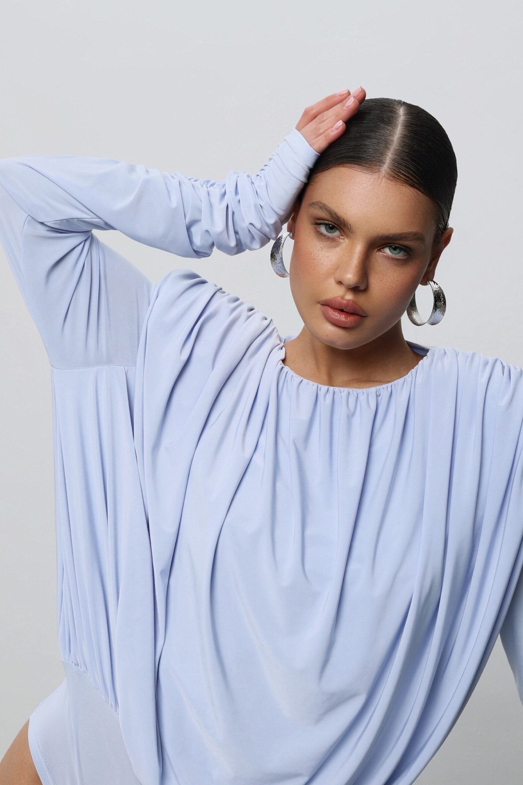 A bodysuit with voluminous shoulders and an open back