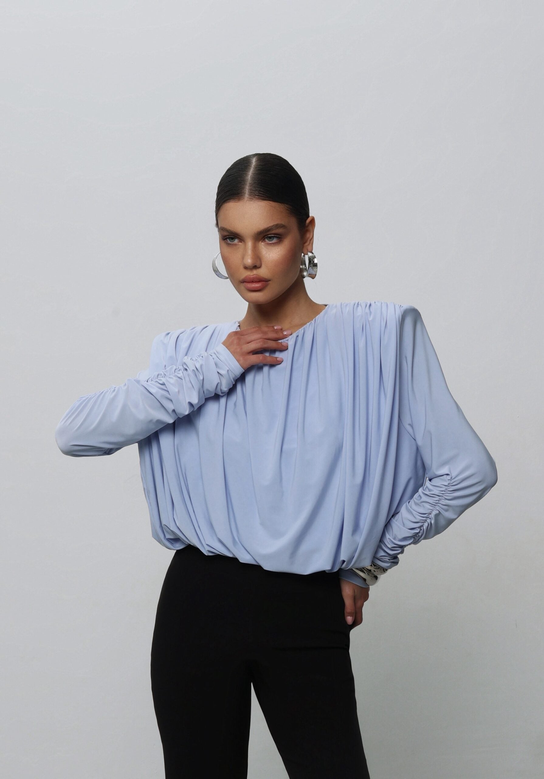 A bodysuit with voluminous shoulders and an open back